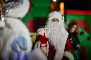 Actor dressed as father christmas pointing at frostie