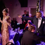 Actor pointing gun at actress