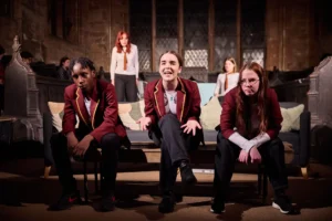 Two actresses and actor sat on sofa