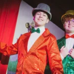 Two actors with sparkly suits and hat