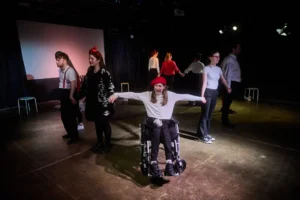 Ensemble of actors holding hands in circle