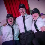 Three actors hugging