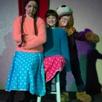 Three child actors. One dressed as a bear