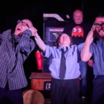 Actress pinching the ears of two actors