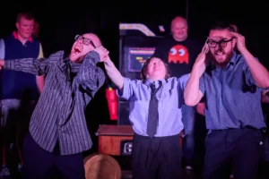 Actress pinching the ears of two actors