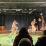 Actor dressed as fox, chasing another actor