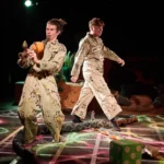 Actor blowing into pipe