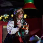 Actress dressed as elf painting toy