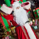 Actor dressed as santa clause with elf on head