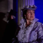 Actress dressed in edwardian clothing looking back