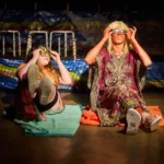 Actor dressed a woman sat on floor with actress