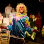 Actror dressed as woman smiling