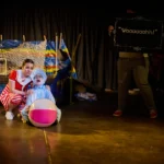 Child actor dressed as a baby and actress comforting them