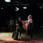 Actress in sunglasses and fur coat with suitcase