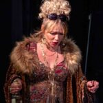 Actress dressed in fur coat looking down