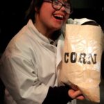 Actor dressed as chef holding bag of corn