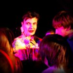 Esemble surrounding actor looking far ahead