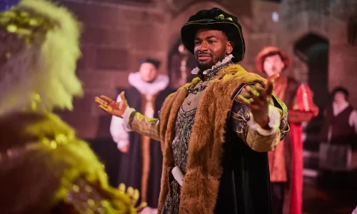 An actor dressed as a Tudor nobleman performing inside St Mary's Guildhall Coventry.