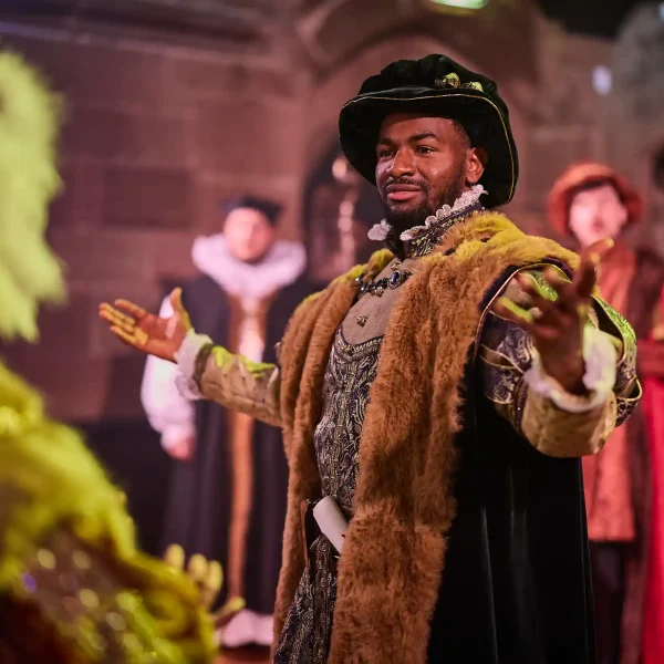 An actor dressed as a Tudor nobleman performing inside St Mary's Guildhall Coventry.
