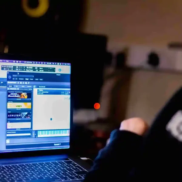 The view over the shoulder of an EGO artist creating beats on his laptop.