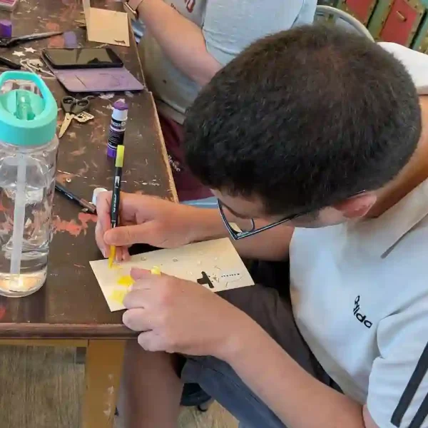 An EGO Artist with his head down focusing on his pencil work.