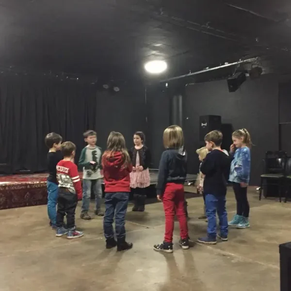 A circle of 10 young actors in a rehearsal.