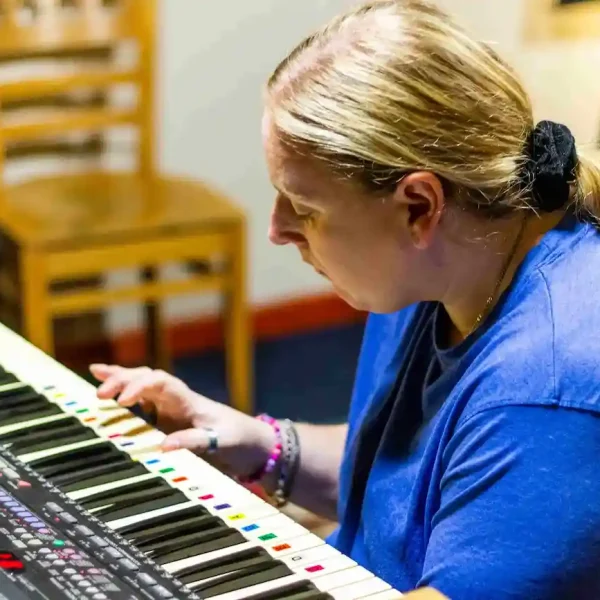 A woman playing the keyboard in a music studio.